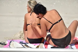 Blonde and brunette on the beach looking sexy in their bikinis