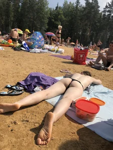Topless Skinny Girl With Very Pale Skin Lying on a Beach on Her Tummy With Slightly Spread Legs Creepshots Gallery