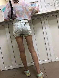 Girl in Denim Shorts With Very Skim Hot Legs And Worn Sneakers at the Reception Desk