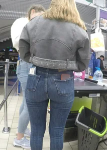 Two hot milfs in tight blue jeans standing at the cash register at the supermarket, awesome big butts