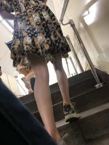 Low angle pics of a candid girl wearing a dress with long and very slim legs