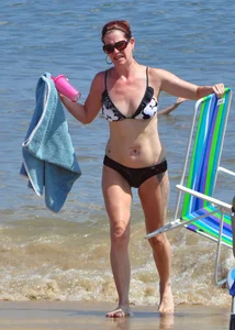 Tattooed redhead milf in a bikini at the beach