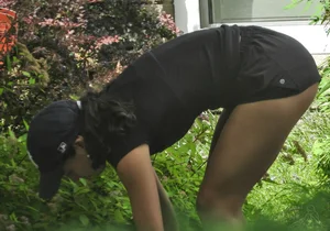 Brunette gardener in shorts bends over… and over as she works [085]