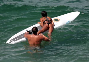 Black girl on the beach in a bikini with an incredible ass while surfing