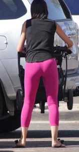 Milf brunette in purplish-pink leggings looking sexy in the parking lot