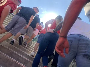 Bunch of girls in various outfits at a Cardinals baseball game