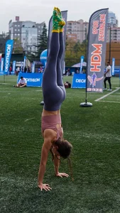 Incredibly Muscly And Fit Girl in Leggings And Cute Socks Doing a Handstand on a Football Field
