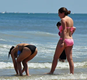 Two teen friends in bikinis at the beach