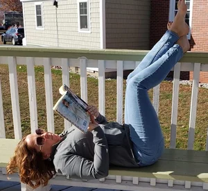 Candid milf in jeans chilling on a bench reading a book