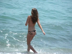 Topless girl with tan lined tits and in a black thong bikini