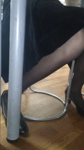 Legs of a Young Girl in a Long Skirt And Pantyhose Under Table Photo