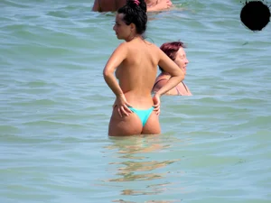 Brunette topless babe with cute tits and a nice ass in a thong bikini