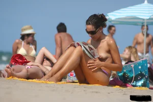2 topless girls at the beach in thongs