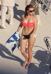Sexy red haired girl in pink and black bikini at the pool