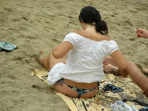 Sexy girl in a blue floral thong bikini at the beach