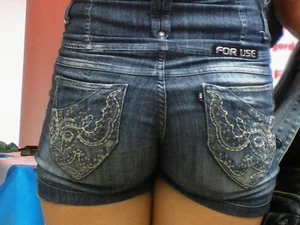 Redhead girl with her cheeks eating her denim shorts