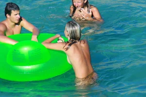 FKK Nudists playing in the water with floater