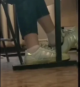 Teen student dangling her sneakers in classroom closeup videos