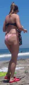 Chunky beach blonde babe in a pink thong bikini