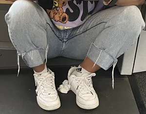 Girl in Blue Jeans And Sneakers Sitting on the Floor With Spread Legs Creepshot