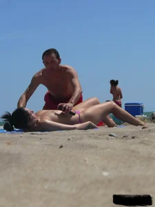 Purple thong topless lady on the beach gets oiled up by her husband