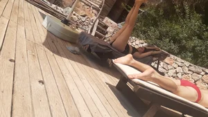Sexy girl stretching herself while laying on sunbed