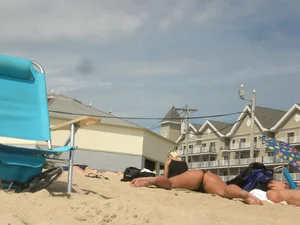 Milf laying out on a beach in Maine in her little thong