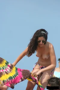 2 topless girls at the beach in thongs