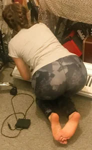 Barefoot girl with braided hair in camo leggings doggy style on the floor home photo