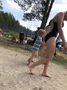 Cute Barefoot Girl in a Black Body Swimsuit Walking on a Road