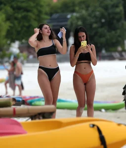 Sexy brunette friends on the beach in bikinis with great bodies
