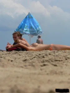 Two topless friends on the beach with nice boobs