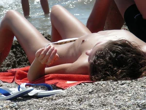Sexy topless girl on the beach in a thong bikini