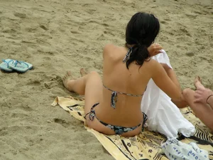Sexy girl in a blue floral thong bikini at the beach