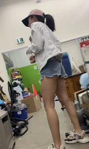 Tight bum hanging out of jean shorts in thrift shop