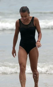 Skinny sexy lady on the beach in a black swimsuit