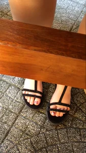 Closeup of candid feet in sandals under table