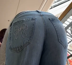 Booty in Bow Bottom Blue Jeans Bends Over, Closeup From Below