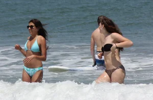 Brunette and redhead on the beach in bikinis looking sexy