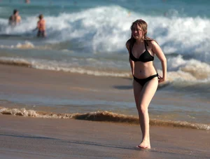 Cute bikini girl in the water in a black bikini