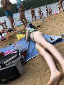 Cute Candid Girl in a Green Swimsuit With Pale Skin Lying on the Beach