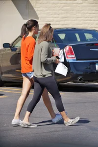 Brunette in tiny shorts walking with her sexy friend in leggings