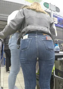 Two hot milfs in tight blue jeans standing at the cash register at the supermarket, awesome big butts