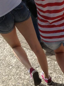 Nice petite booty and long slim legs wearing denim shorts, candid girl with a backpack walking down the street
