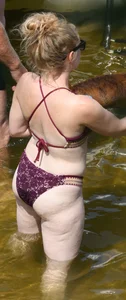 Chunky blonde enjoying some drinks in the water in her purple bikini