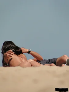 Topless lady on the beach in a gold thong with a nice ass