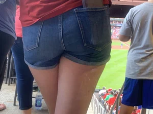 Bunch of girls in various outfits at a Cardinals baseball game