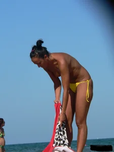Bunch of sexy babes on the beach topless and in thong bikinis