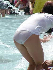 Candid young candid girl in wet panties and T-shirt playing in fountain