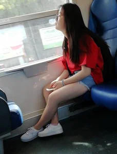 Two cute Asian teens on the bus in shorts showing their legs